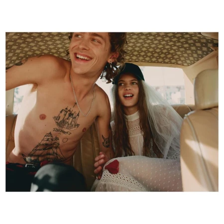 Young tattooed man and a woman in a wedding dress inside a car interior photographed by Ward and Kweskin