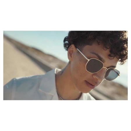 Close-up portrait of a person wearing sunglasses and a white shirt outdoors by Ward & Kweskin