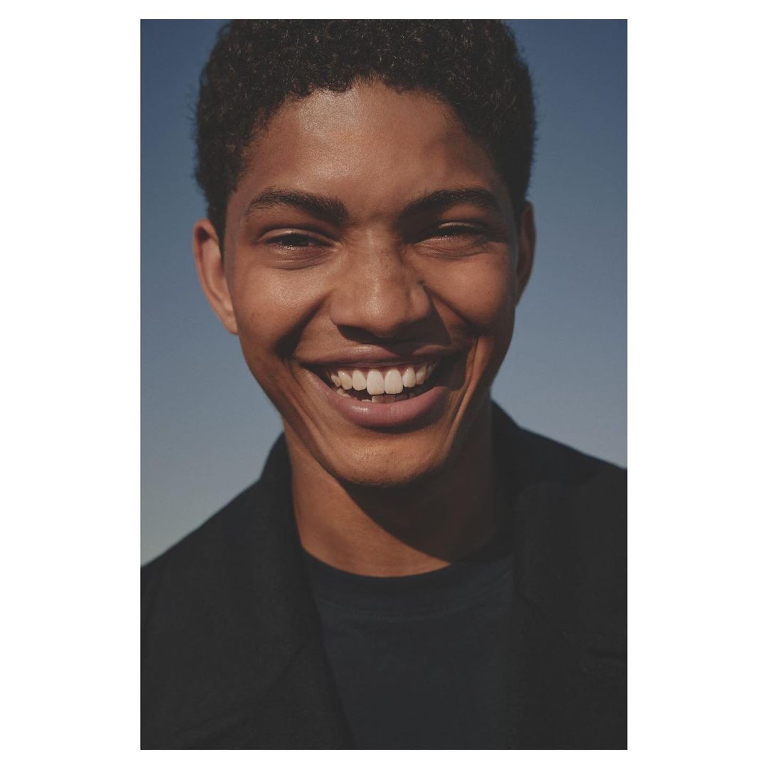 Close up portrait of smiling young man against clear blue sky by Ward and Kweskin