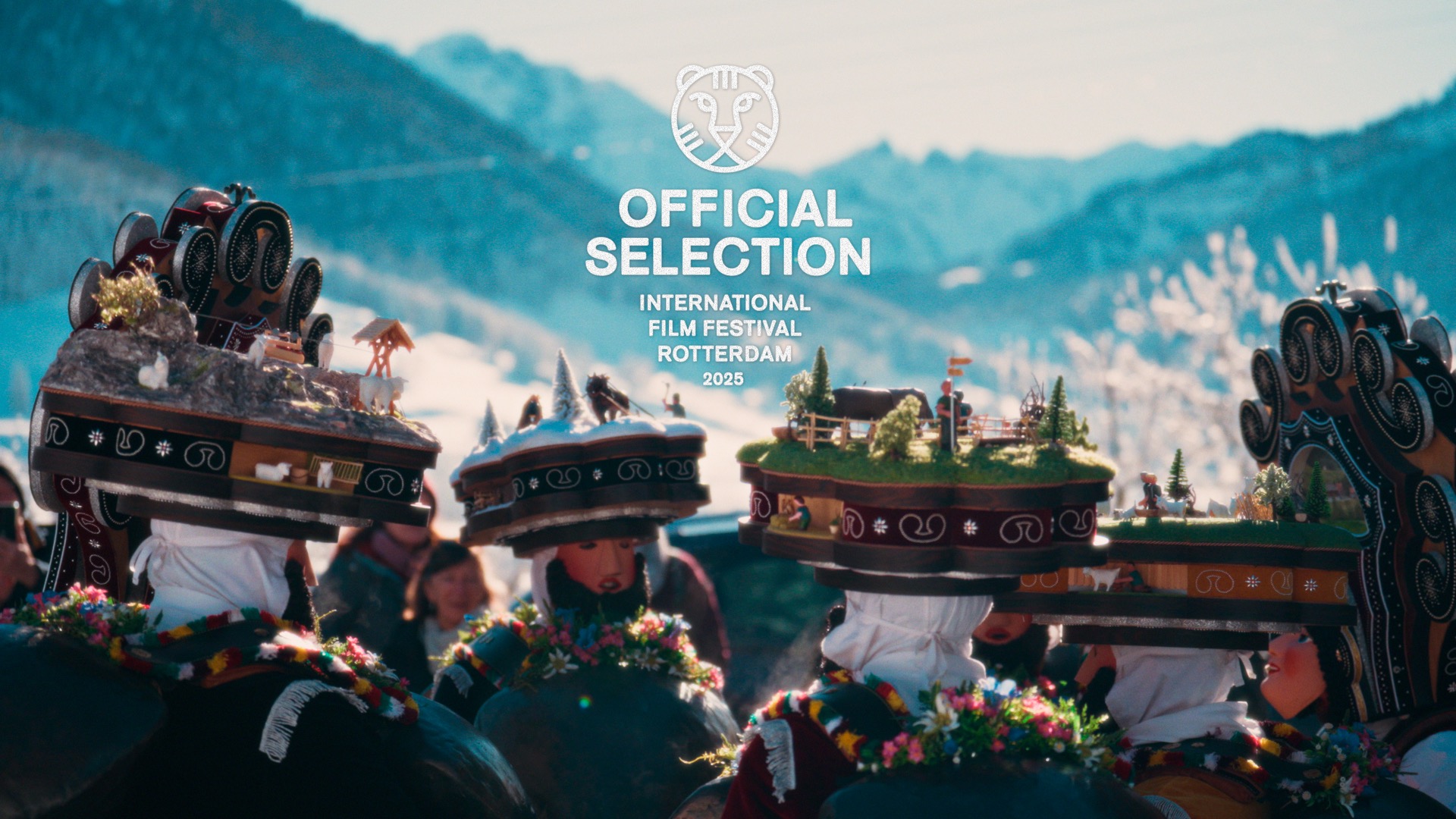 Film festival promo features a group with elaborate headwear in a snowy mountain setting. The headwear includes miniature landscapes.