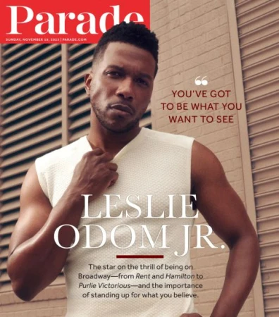 Magazine cover featuring Leslie Odom Jr. in a sleeveless top, posing against a light brown wall with louvers. He is center frame.