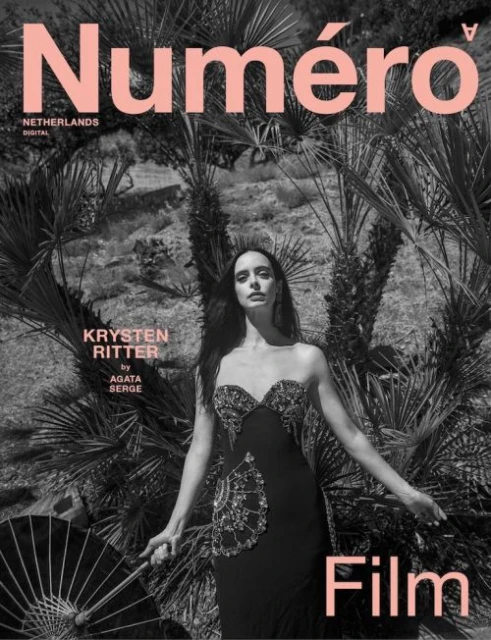 Magazine cover featuring Krysten Ritter in black dress, holding parasol, against arid landscape with 'Numero Netherlands' text overlay.