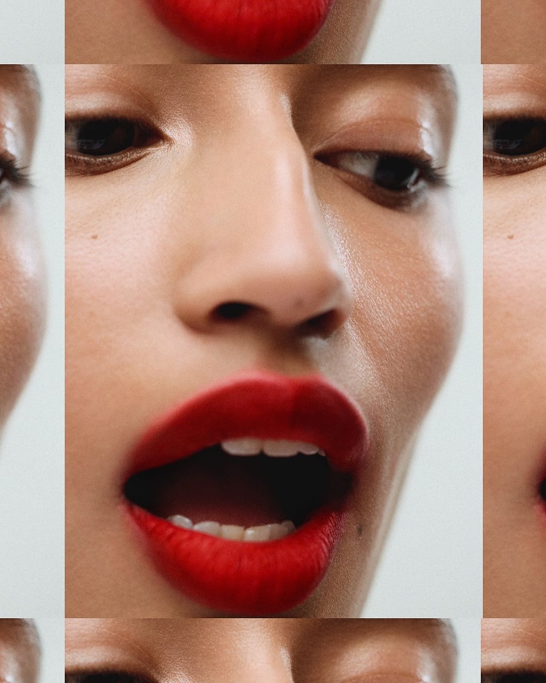 Extreme close-up of a woman's face with red lipstick, highlighting her open mouth, nose, and eyes, with a soft, diffused lighting.