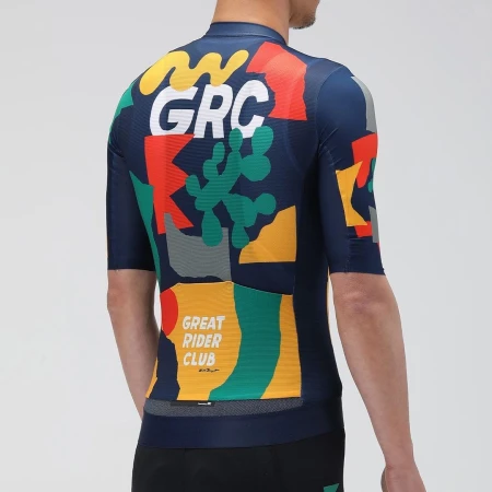 Back view of a person in a patterned cycling jersey with graphic elements, GRC text, and geometric shapes against a neutral backdrop.