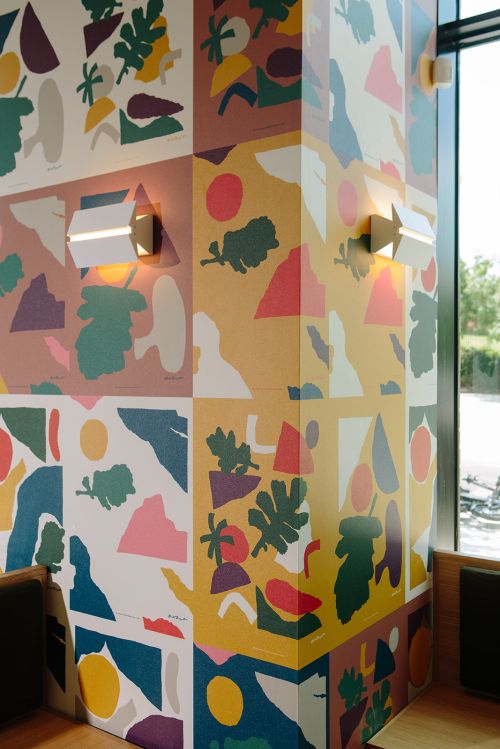 Modern interior design featuring an accent wall with colorful, abstract wallpaper and contemporary wall sconces, adding a unique, artistic touch.