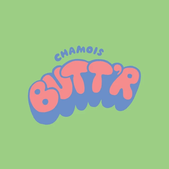 Chamois Butt'r logo in pink and blue against a green background, featuring a rounded, cartoonish font. Clean and simple.