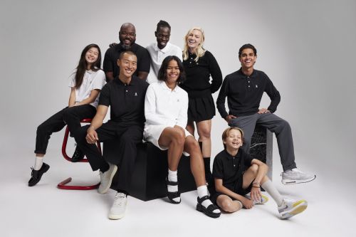 Group portrait of eight diverse people in polo shirts and casual wear sitting, standing, and posing in a brightly lit studio.