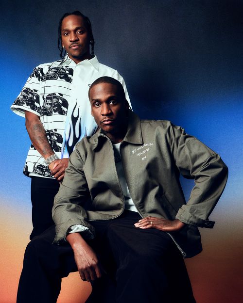 Portrait of Pusha T and No Malice in fashionable jackets against a gradient blue and tan backdrop. Music, celebrity, and fashion.