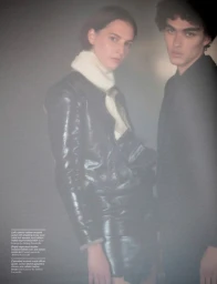 Two models posed against a moody, hazy background, featuring glossy black leather and knitwear styled by Mika Curella.