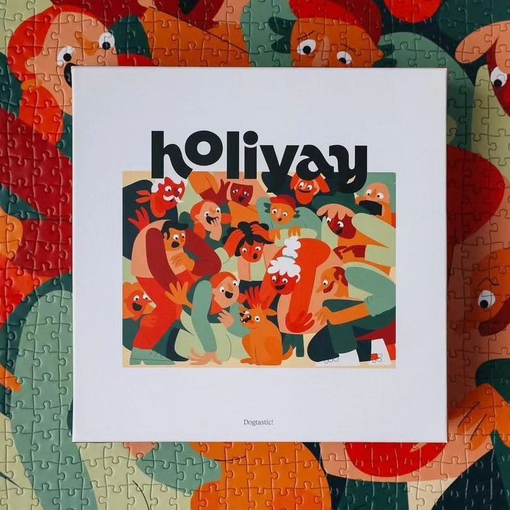A jigsaw puzzle box depicts a cartoon crowd illustration. The title 'holiyay' is prominent, with vibrant colors and intricate details.