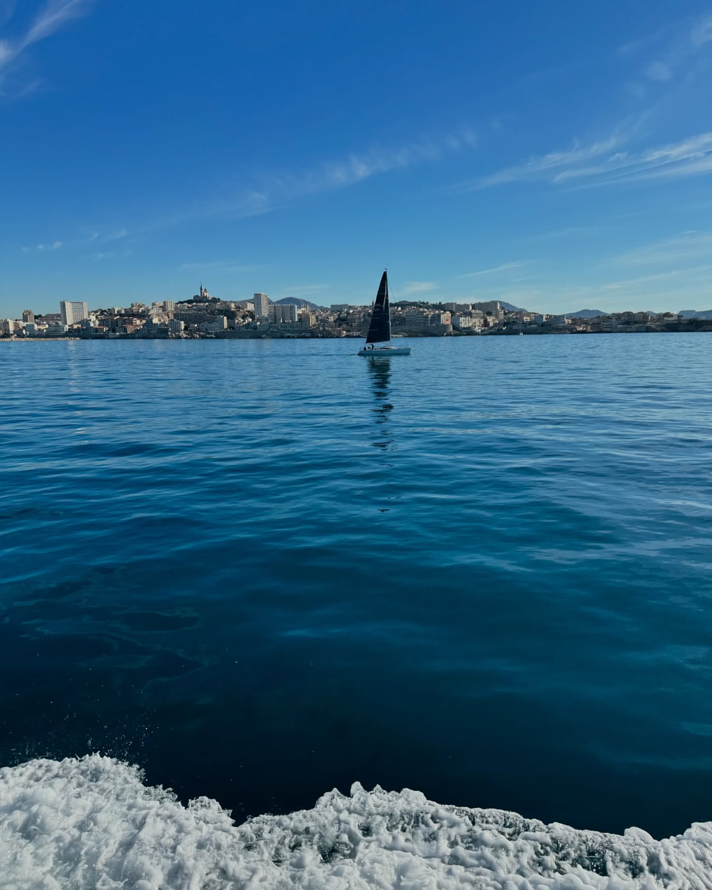Sailboat navigating the Mediterranean Sea near Marseille, France, under a clear blue sky, capturing a serene maritime scene.