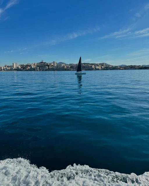 Sailboat navigating the Mediterranean Sea near Marseille, France, under a clear blue sky, capturing a serene maritime scene.