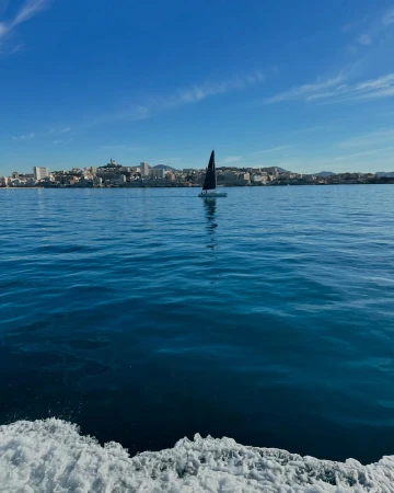 Sailboat navigating the Mediterranean Sea near Marseille, France, under a clear blue sky, capturing a serene maritime scene.