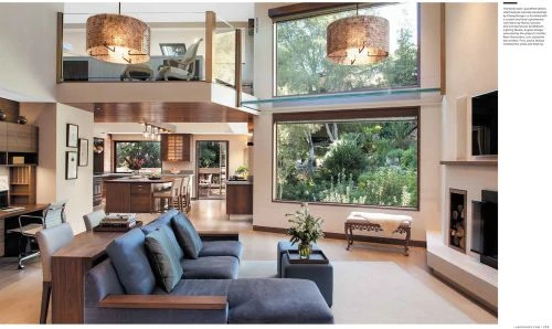 Interior of a modern, multi-level house with large windows, open floor plan, and contemporary furniture and lighting, showcasing residential architecture.