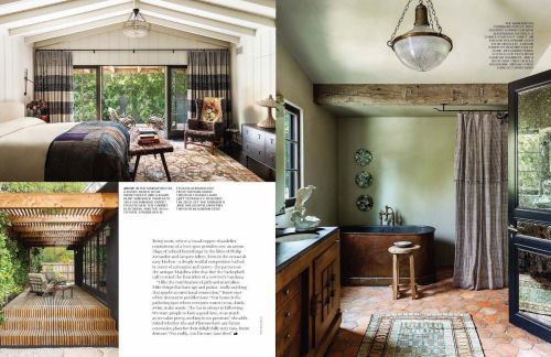 Interior design of a bedroom with an open door to a garden and a bathroom with a copper tub and a natural color palette.