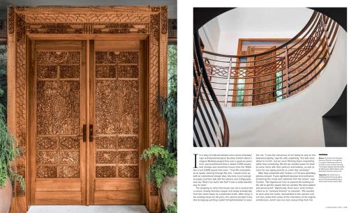 Ornate wooden double doors with carved patterns, framed by greenery, showcase craftsmanship and architectural detail.