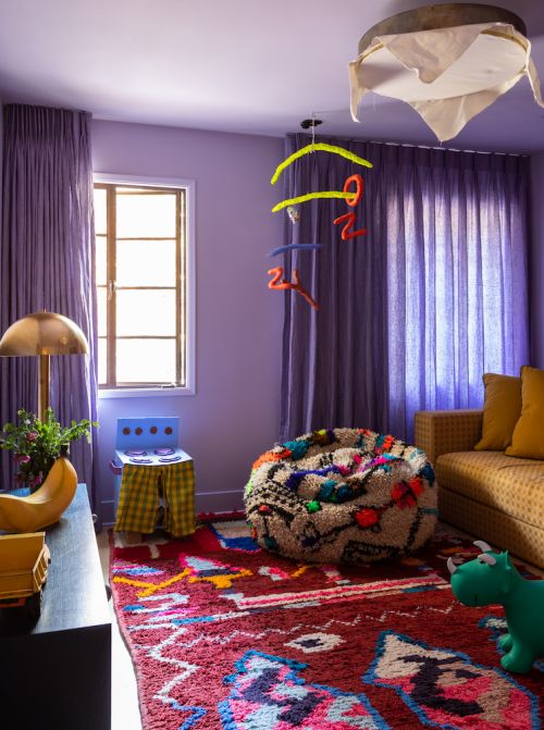 Colorful kid's room interior with a vibrant rug, textured beanbag chair, and playful decorations in a cozy home setting.