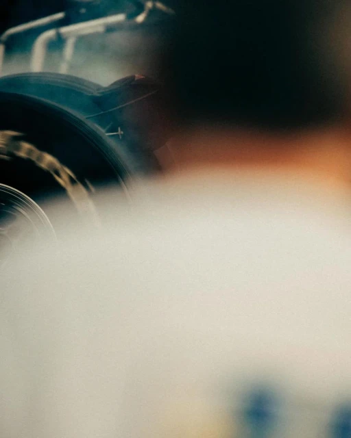Close up of tires on vehicles blurred in motion with a background of fog, depicting speed, potential automotive or sports theme.