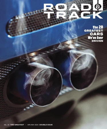 Road & Track magazine cover featuring a close-up of a car's exhaust pipes with visible smoke and a blue reflective surface.