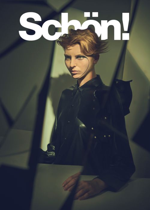 Magazine cover featuring a person with short blond hair, a dark shirt, and geometric background shapes. The magazine's name is "Schön!".
