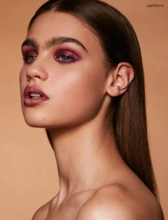 Close up beauty portrait of a woman with plum eyeshadow and dark hair by makeup artist Sophie Ono