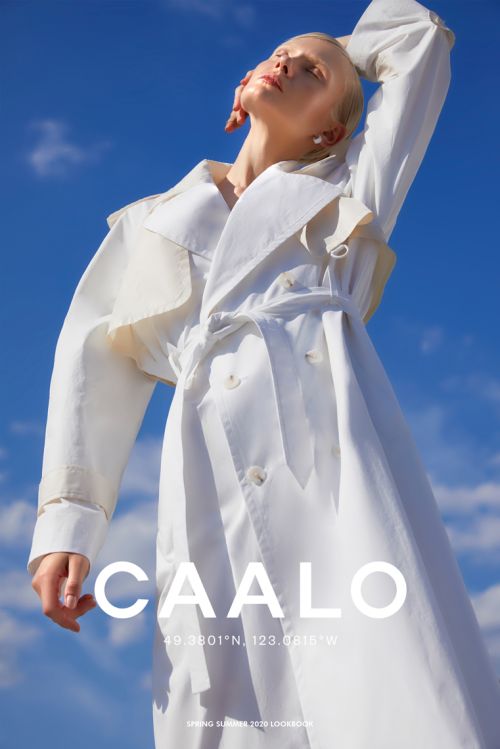 Fashion shot featuring a model in a white trench coat against a blue sky backdrop. The composition emphasizes modern elegance.