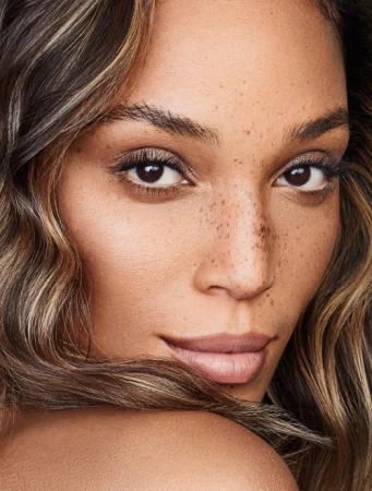 Close-up portrait of a woman with freckles and highlighted hair by make-up artist Sophie Ono