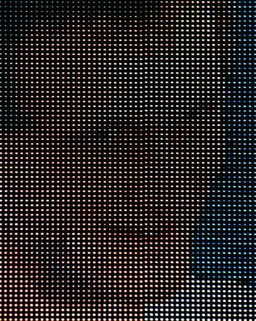 Abstract close-up of a digital display screen with a grid of small, evenly spaced light points in hues of blue, pink, and white.