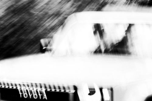 Abstract monochrome image of a Toyota vehicle with motion blur and shallow depth of field, capturing a sense of speed and movement.