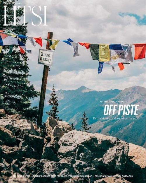 Magazine cover featuring a mountain landscape with colorful prayer flags strung across the top, a sign, and the magazine's title.