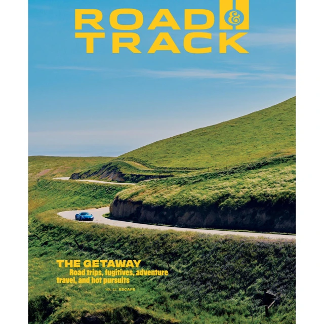 Magazine cover featuring a blue sports car driving on a scenic road with rolling green hills and a bright blue sky in the background.
