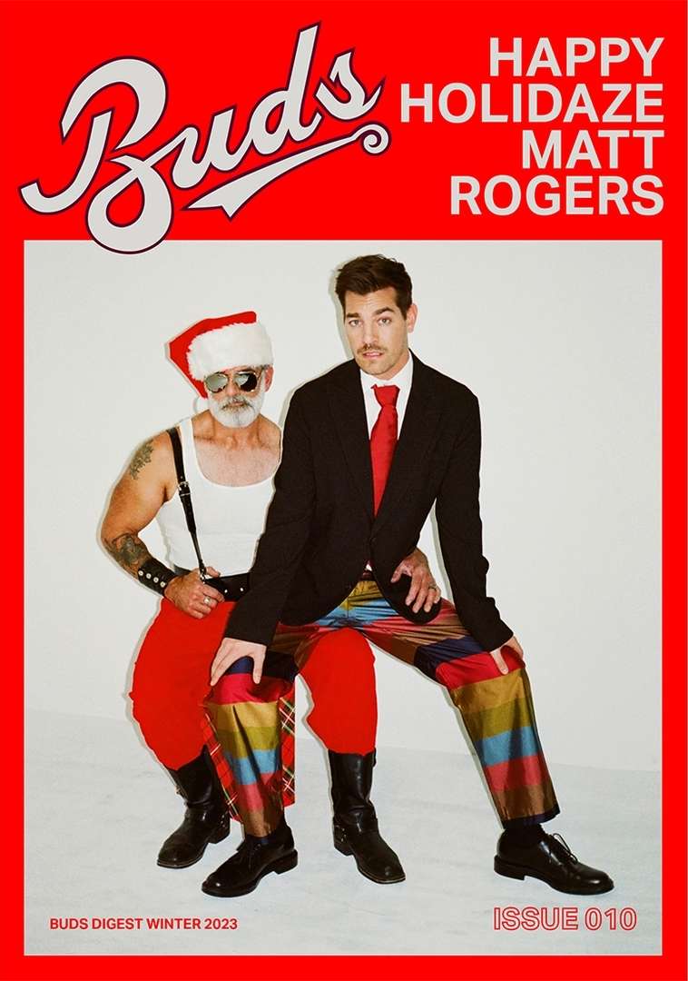 Magazine cover featuring two men: one in a Santa hat and the other in a suit, posing against a bright red backdrop with bold white text.