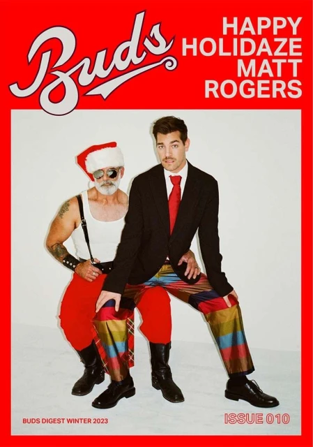 Magazine cover featuring two men: one in a Santa hat and the other in a suit, posing against a bright red backdrop with bold white text.