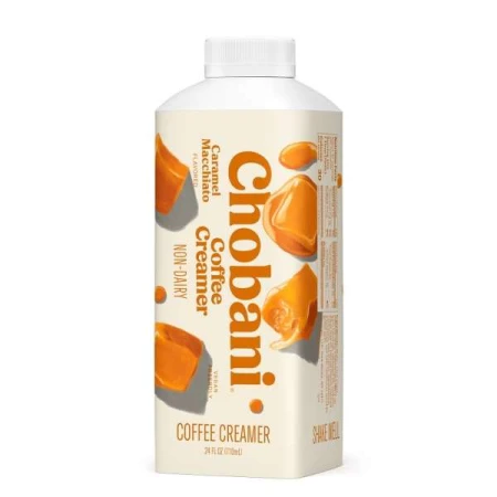 Chobani Caramel Macchiato flavored non-dairy coffee creamer in a white plastic bottle with scattered caramel candy pieces on the label.