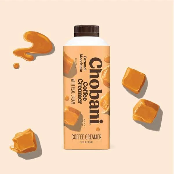 Chobani Caramel Macchiato Coffee Creamer bottle with caramel drizzle and cubes. Beige background, studio shot, product photography.