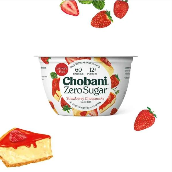 Chobani Zero Sugar Strawberry Cheesecake yogurt container with strawberries and cheesecake slices on a white background.