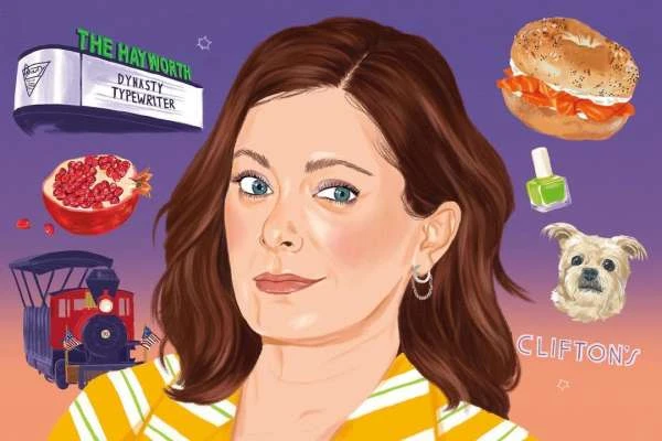 Illustration of a woman with brown hair and blue eyes, against a purple background with a bagel, pomegranate, and miniature train.