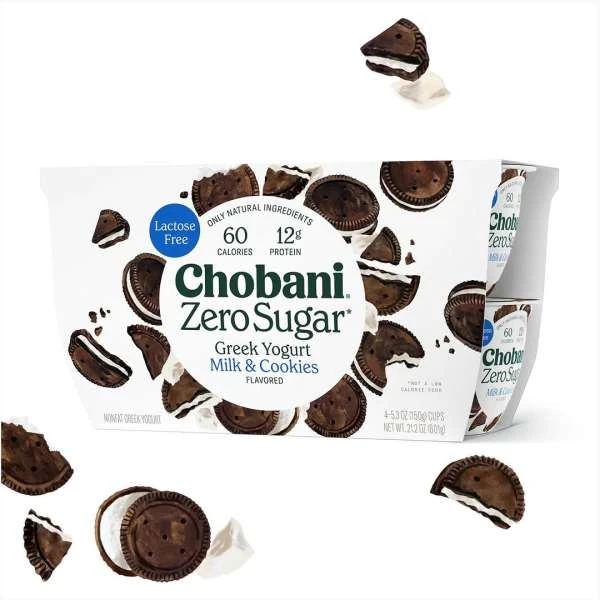 A package of Chobani Zero Sugar Greek Yogurt Milk & Cookies flavor is displayed, surrounded by scattered cookie pieces on white background.