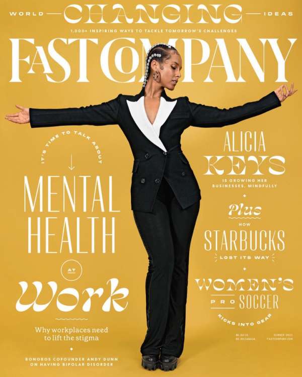 Alicia Keys on a Fast Company magazine cover in a black suit, standing with arms outstretched against a yellow background with white text.