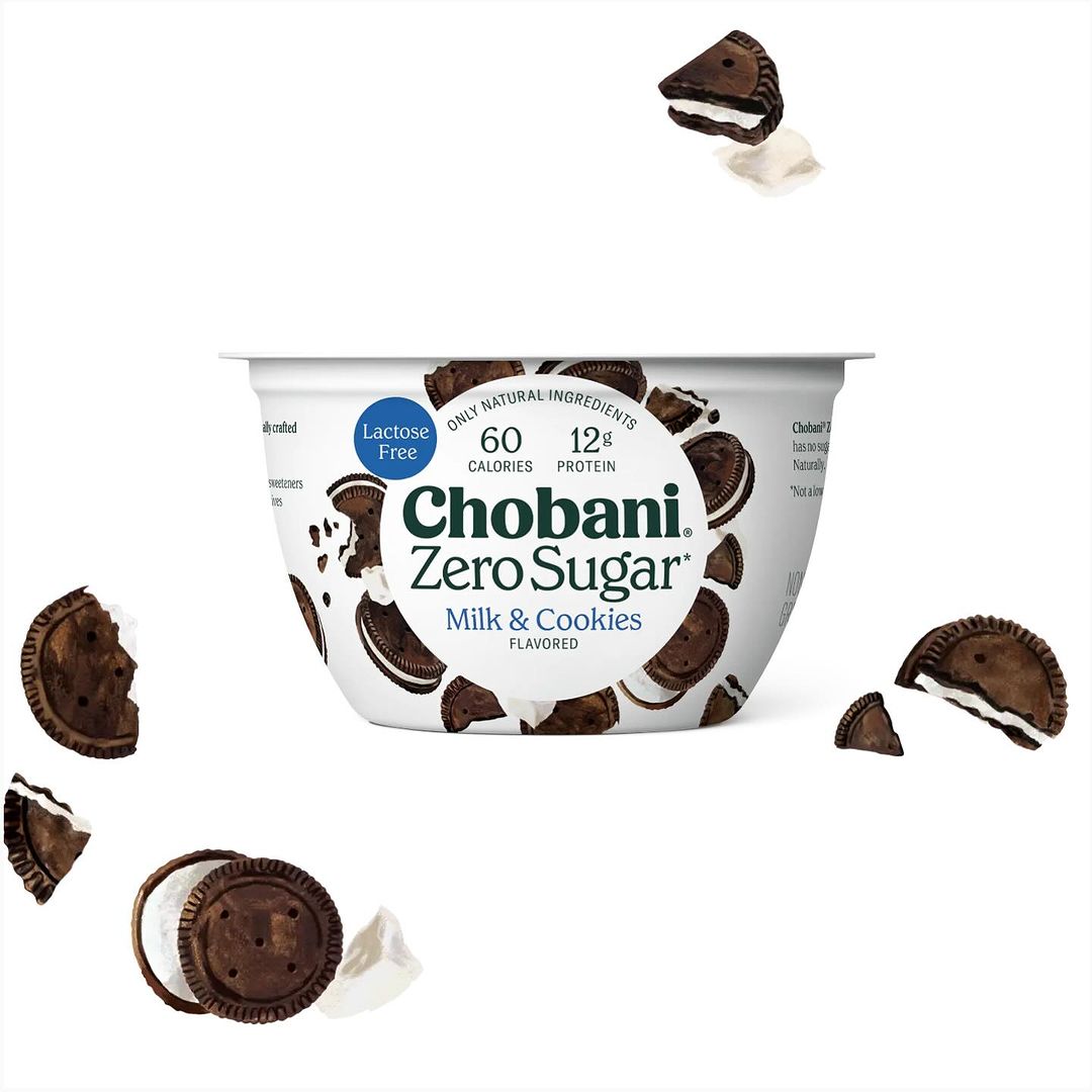 Chobani Zero Sugar Milk & Cookies yogurt container surrounded by cookie pieces, set against a clean white background. Food and beverage.