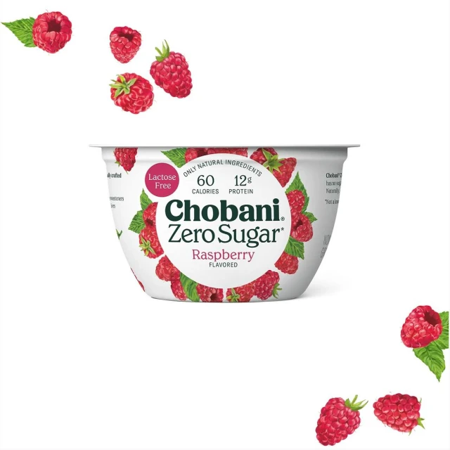 Chobani Zero Sugar raspberry flavored yogurt cup with scattered raspberries on a white background, showcasing a food and beverage product.