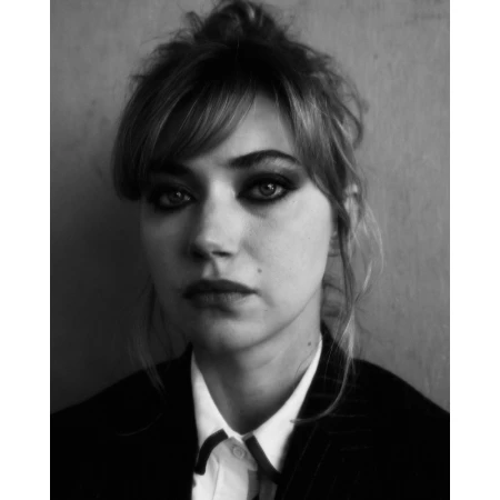 Portrait of a woman with dark eye makeup wearing a collared white shirt and dark jacket by photographer Erik Tanner.
