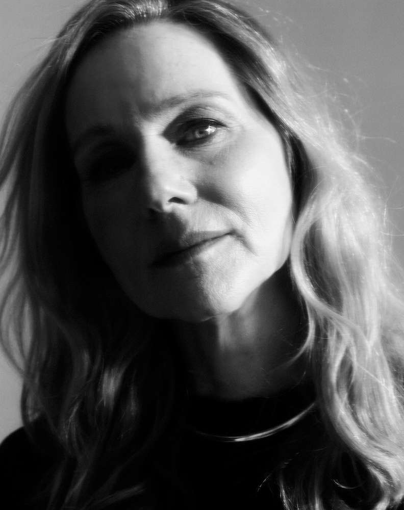 Close-up monochrome portrait of a woman with long blonde hair and a silver necklace by photographer Erik Tanner.
