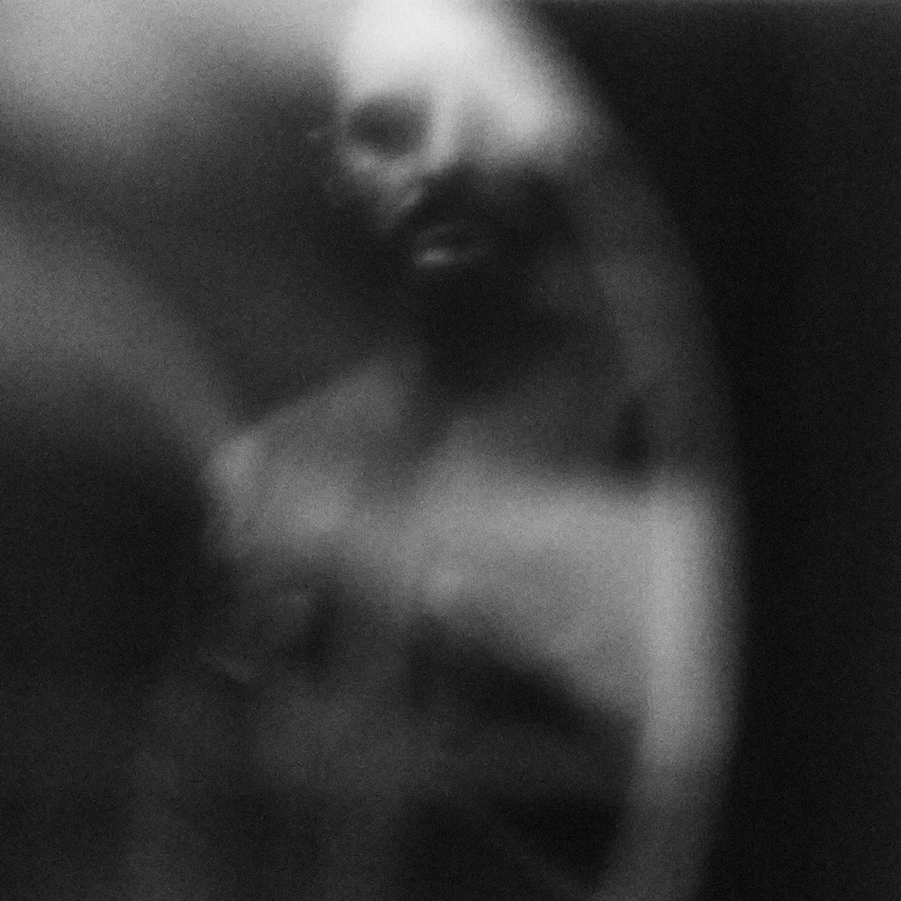 Monochromatic portrait of a man with a beard, captured with soft focus and artistic blur for a fine art feel.