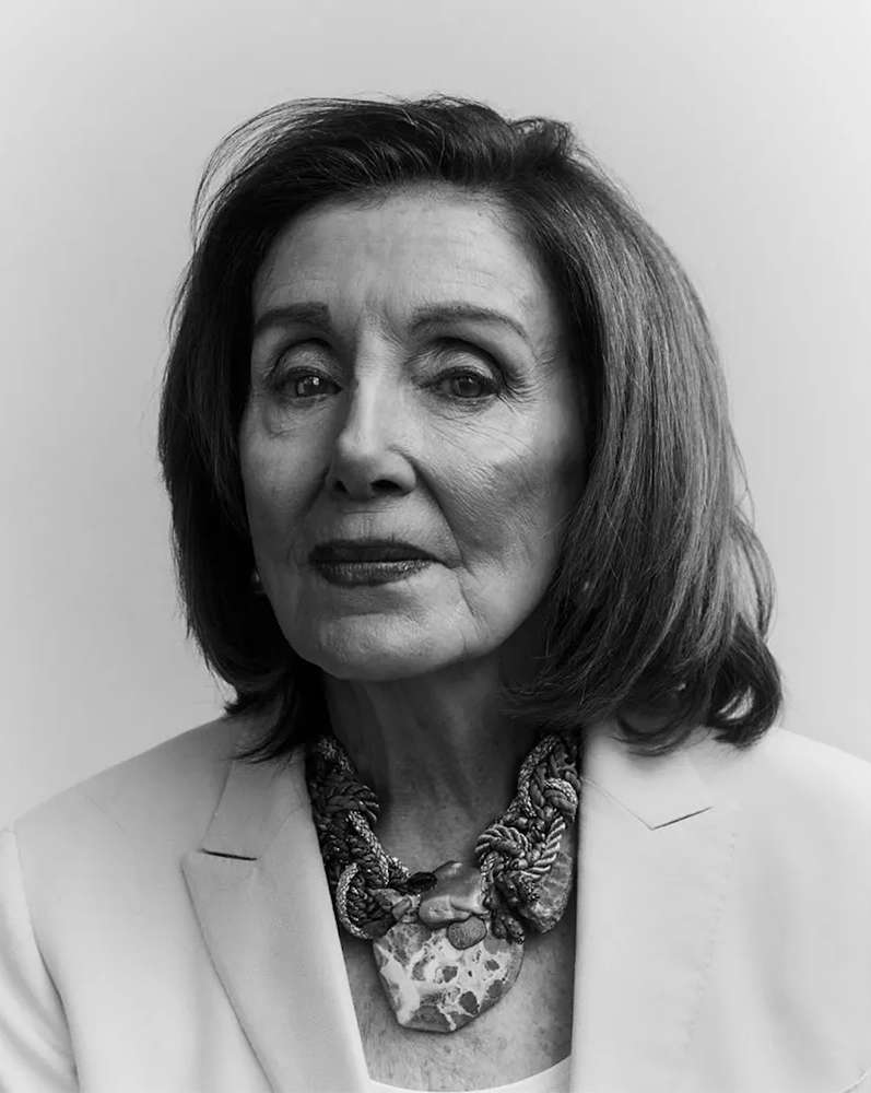 Portrait of Nancy Pelosi wearing a light blazer and statement necklace against a seamless background photographed by Erik Tanner