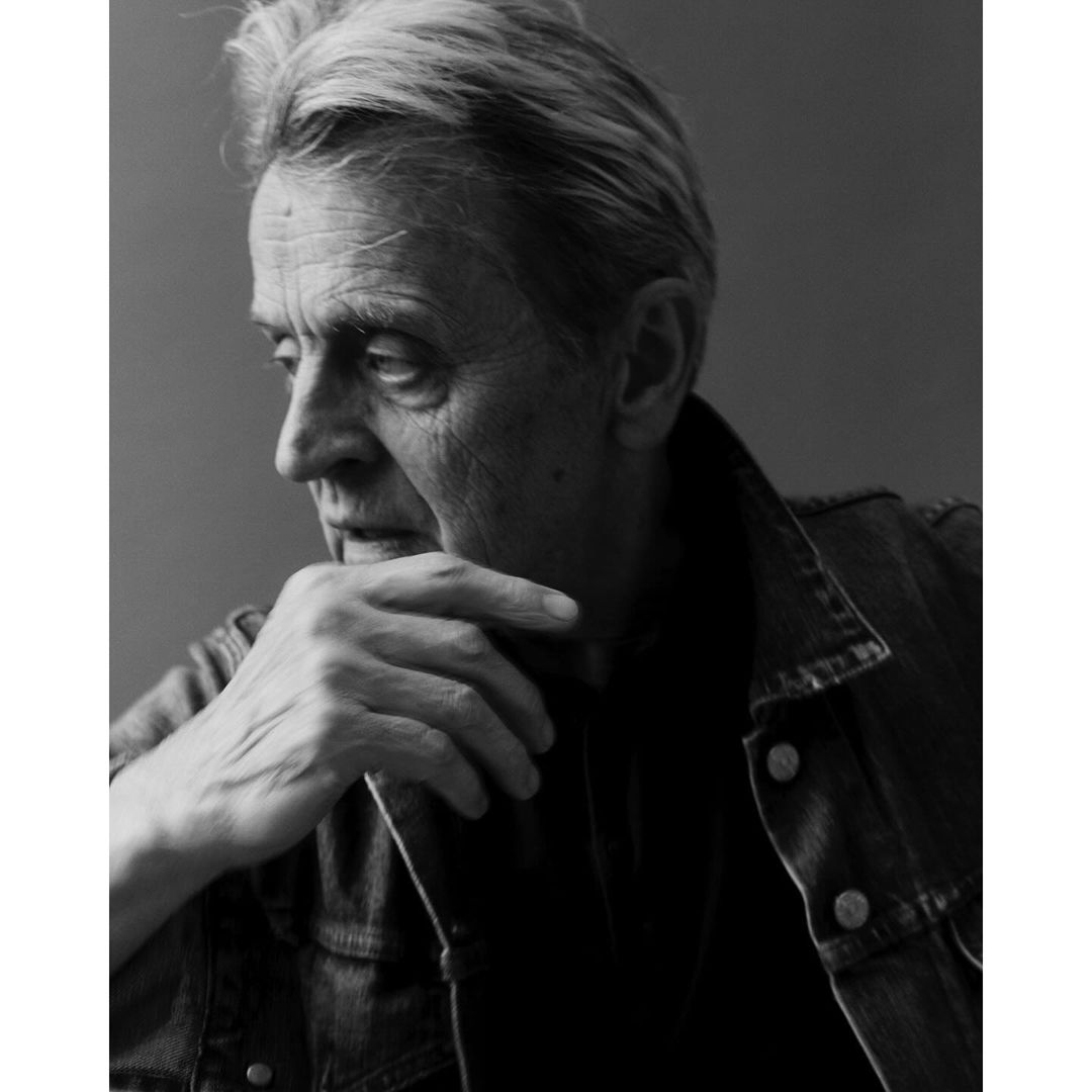 Monochrome portrait of an elderly man with textured hair wearing a denim jacket, photographed by Erik Tanner