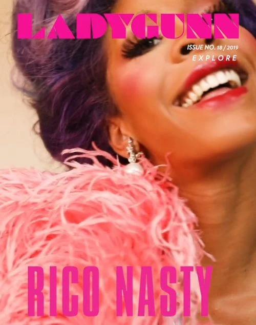 Close-up of Rico Nasty on Ladygunn magazine cover, issue no. 18/2019. She wears bold makeup, purple hair, and a pink feathered boa.