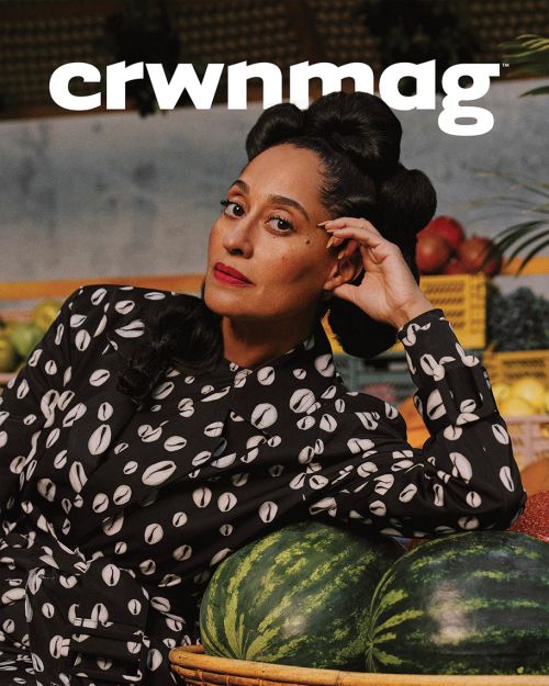 Portrait of a woman with high hairstyle and patterned dress against a fruit display backdrop for CRWNMAG magazine cover.