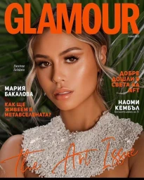 Close-up magazine cover portrait of a woman with blonde highlights wearing a textured white embellished top against tropical leaves