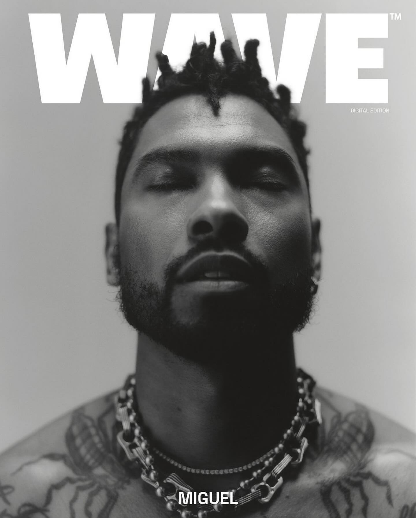 Black and white portrait of Miguel for Wave magazine, showcasing his dreadlocks, jewelry, and tattoos in a close-up studio shot.